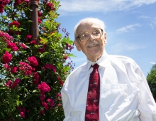 Gene Lang stands front of roses